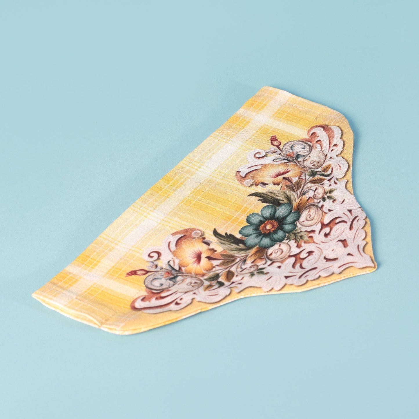 Yellow plaid cat or dog slide-on bandana laying flat  with a white and teal floral scroll design 