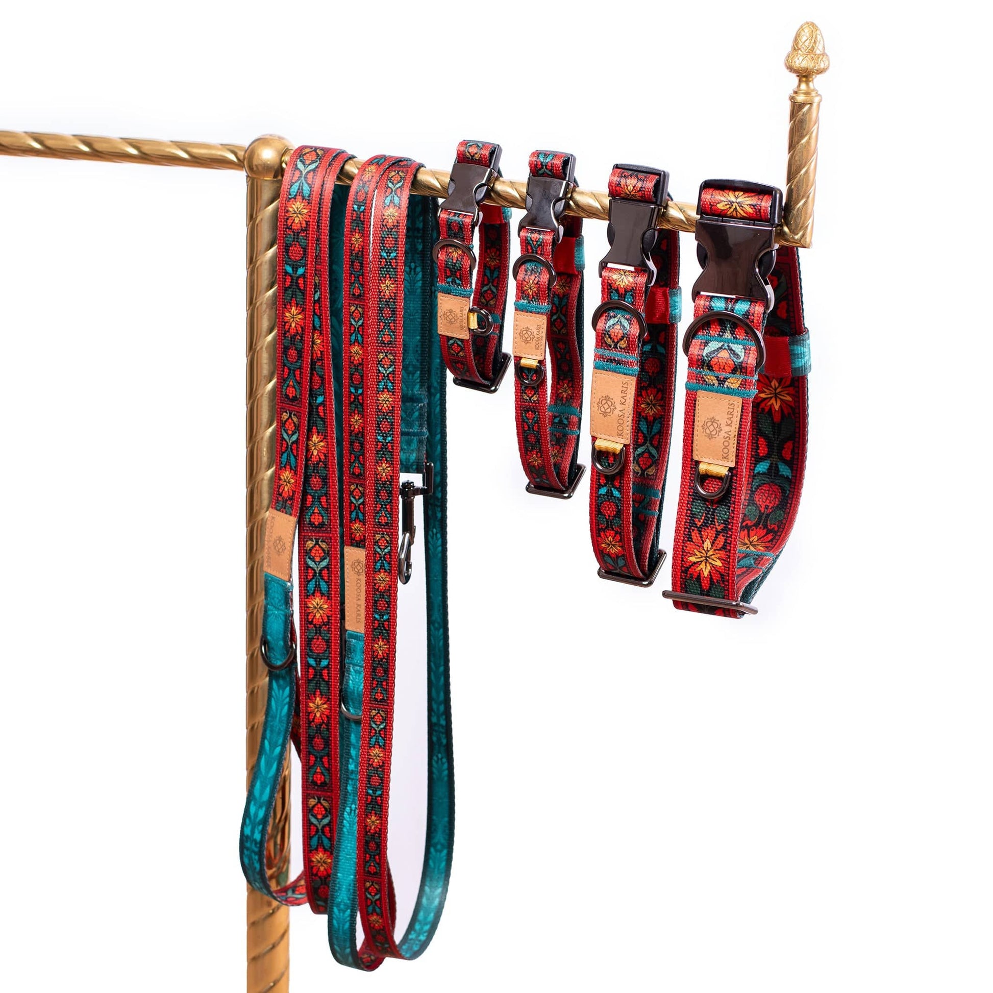 Red dog collars and leashes with gunmetal-toned hardware and a colorful southwestern floral pattern