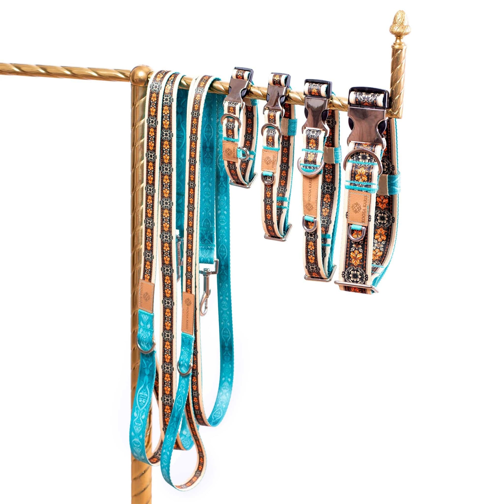 Ivory and turquoise colored dog collars and leashes with silver-toned hardware and a black and gold Western floral pattern 